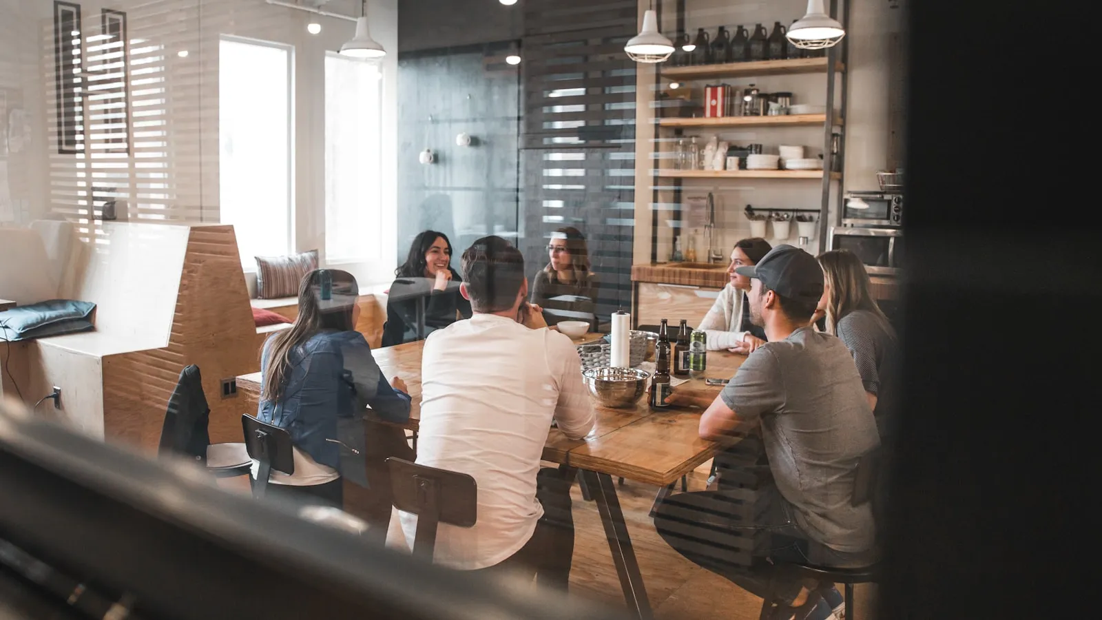 A group of creators gathered around a long wooden table mid-conversation.