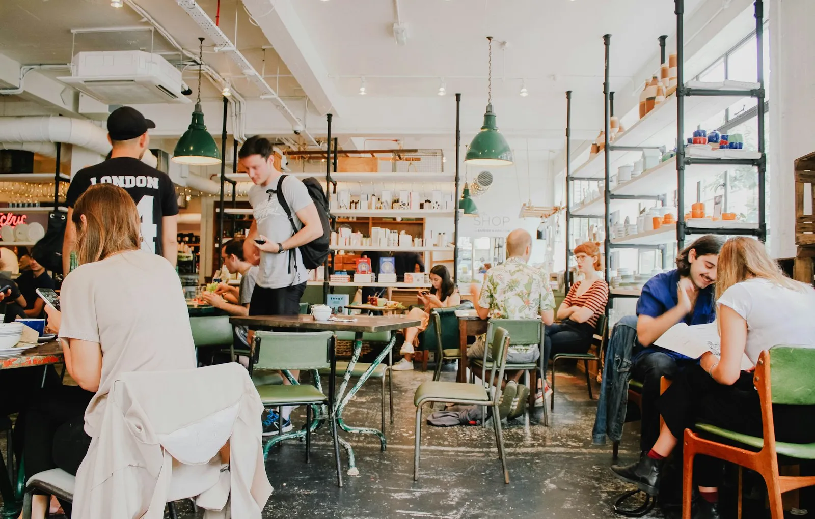 A busy community cafe interior with regulars at communal tables.